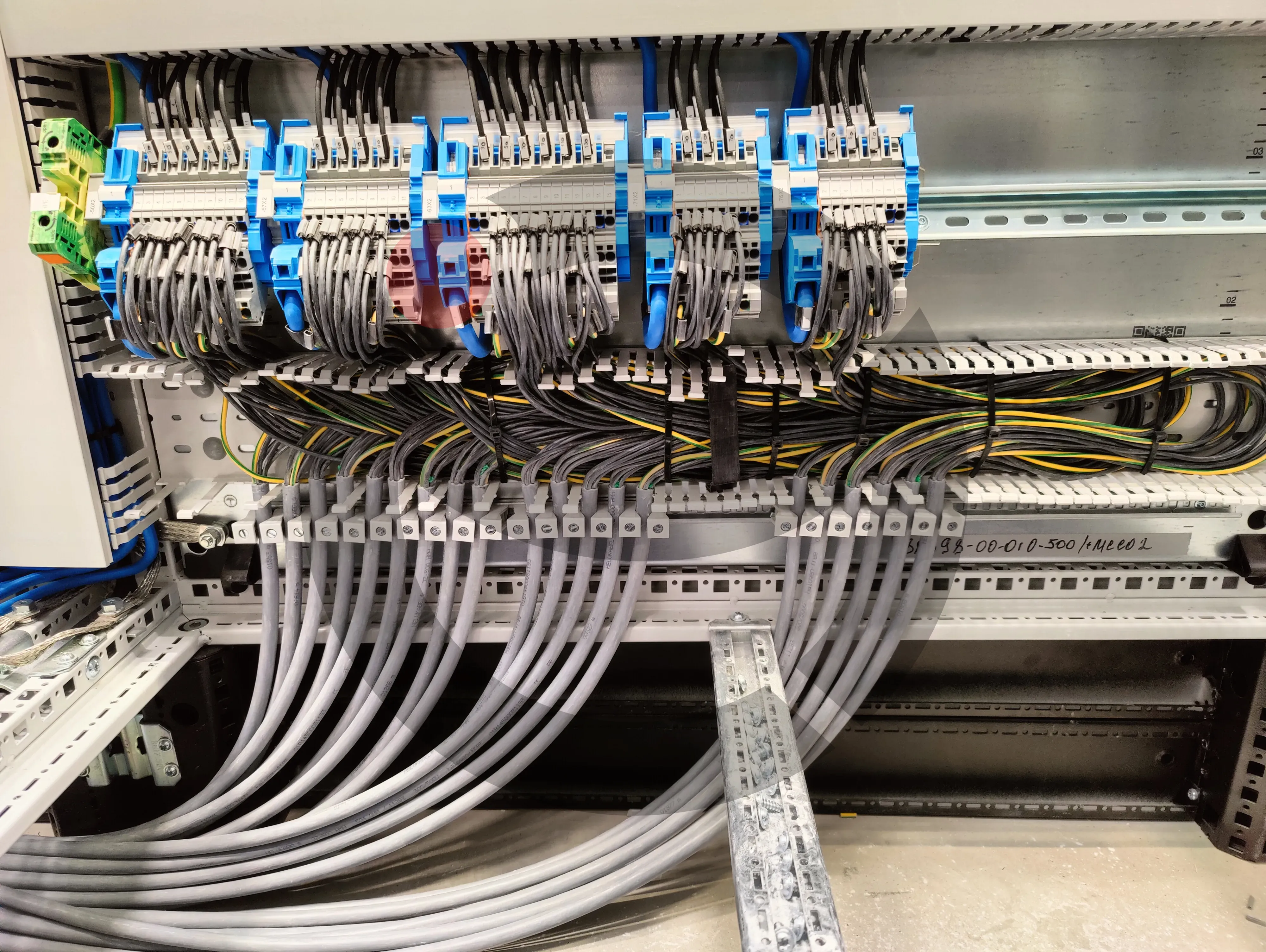 Neatly combed industrial switchgear wiring and DIN rail terminals